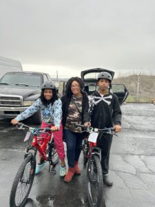 Photo of mom and two children with bikes form the pantry.